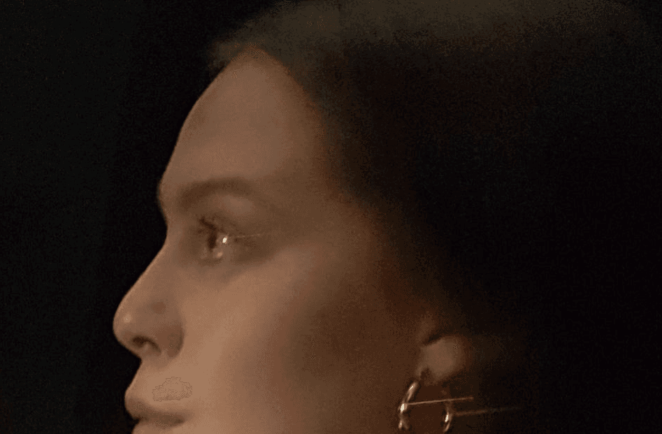 Enya wearing headphones, looking out over a city skyline